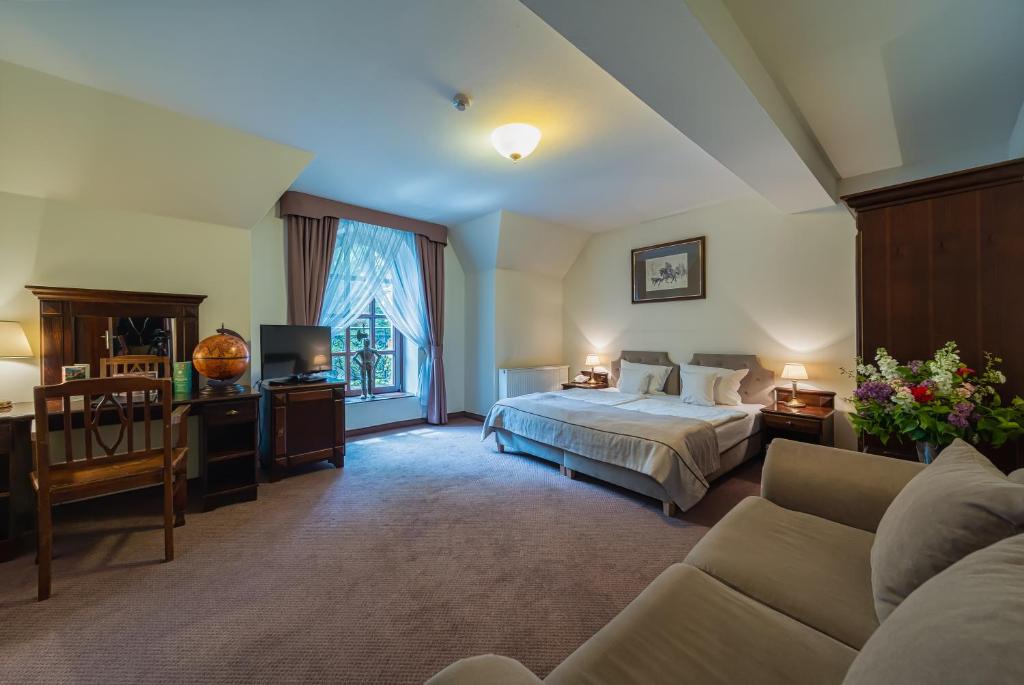 Spacious bedroom with double bed, large window, and cozy seating area.