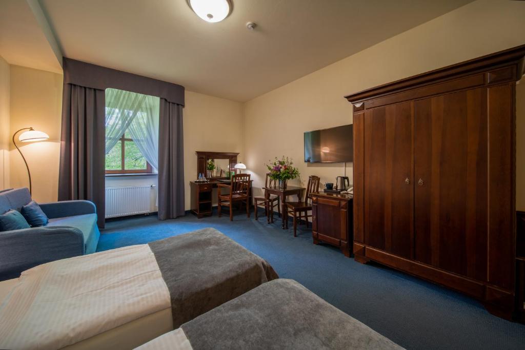 Comfortable room with twin beds, wooden furniture, and a large window.