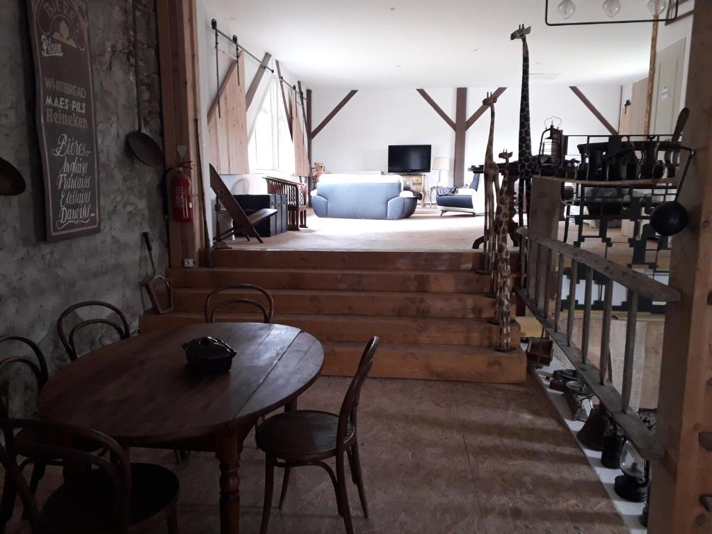 - une chambre avec une table, des chaises et un canapé dans l'établissement La fermette, à Saint-Marcellin