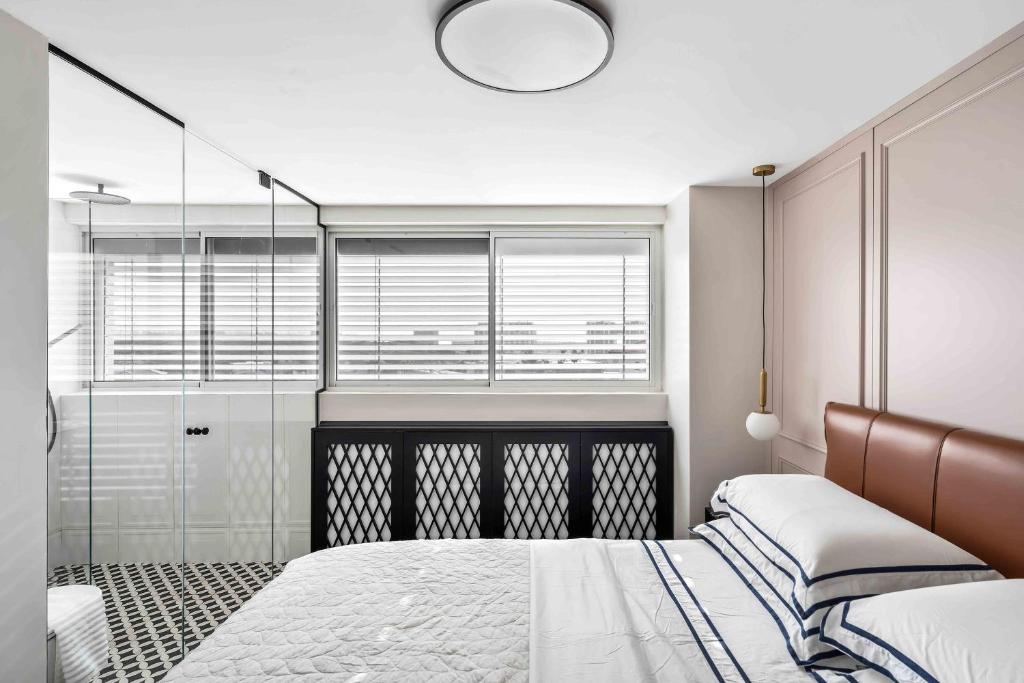 een slaapkamer met een bed en een glazen douche bij Elegant Beachfront Duplex with Private Parking in Herzelia 