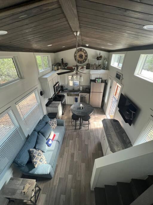 Fox Hollow - Tiny home with Cypress Creek access, park like setting في ويمبيرلي: غرفة معيشة مع أريكة زرقاء وطاولة