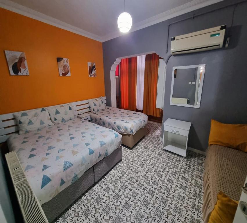 - une petite chambre avec 2 lits et un miroir dans l'établissement My Home Taksim, à Istanbul