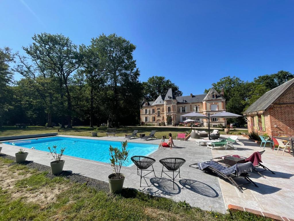 a swimming pool in front of a house at Château Les Villiers - Au cœur de la Sologne in Villeny