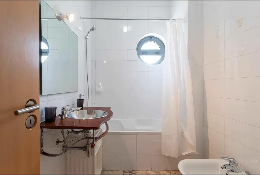 a bathroom with a sink and a bath tub at Arrábida Resort in Quinta do Anjo