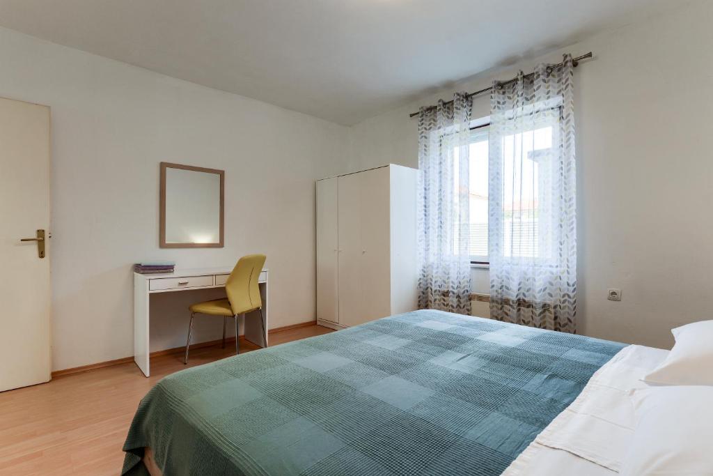 - une chambre avec un lit, un bureau et une fenêtre dans l'établissement Apartman Klarin, à Zadar
