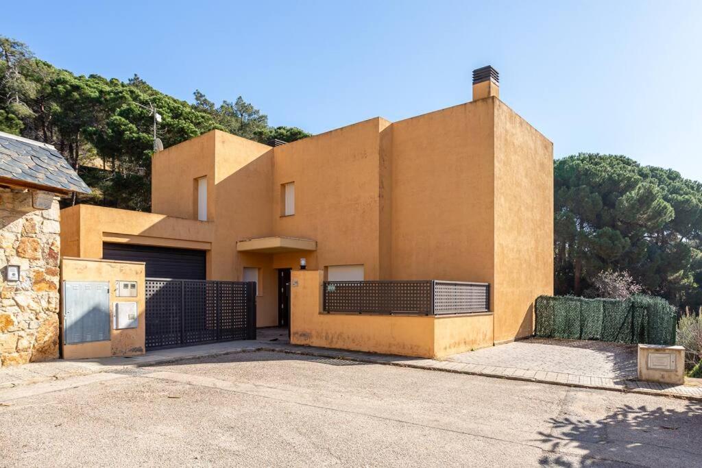 um edifício castanho com um portão em frente em Villa Tambora- Costa Brava em Lloret de Mar