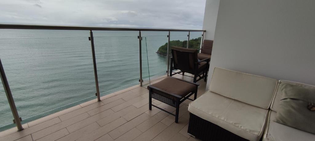 balcón con sofá, sillas y el océano en Ph El Palmar Residenses, en El Nance