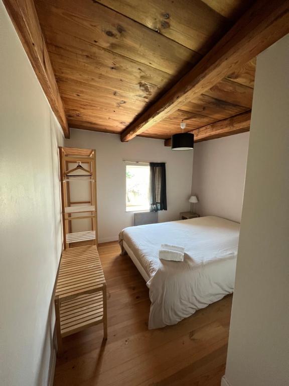 een slaapkamer met een bed en een houten plafond bij Grand Gîte Confortable en Auvergne - Belle vue in Brousse