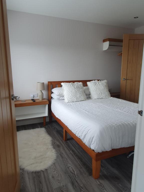 a bedroom with a bed with white sheets and pillows at Self catering. Maydene. Holm. Orkney, Scotland. in Nether Button