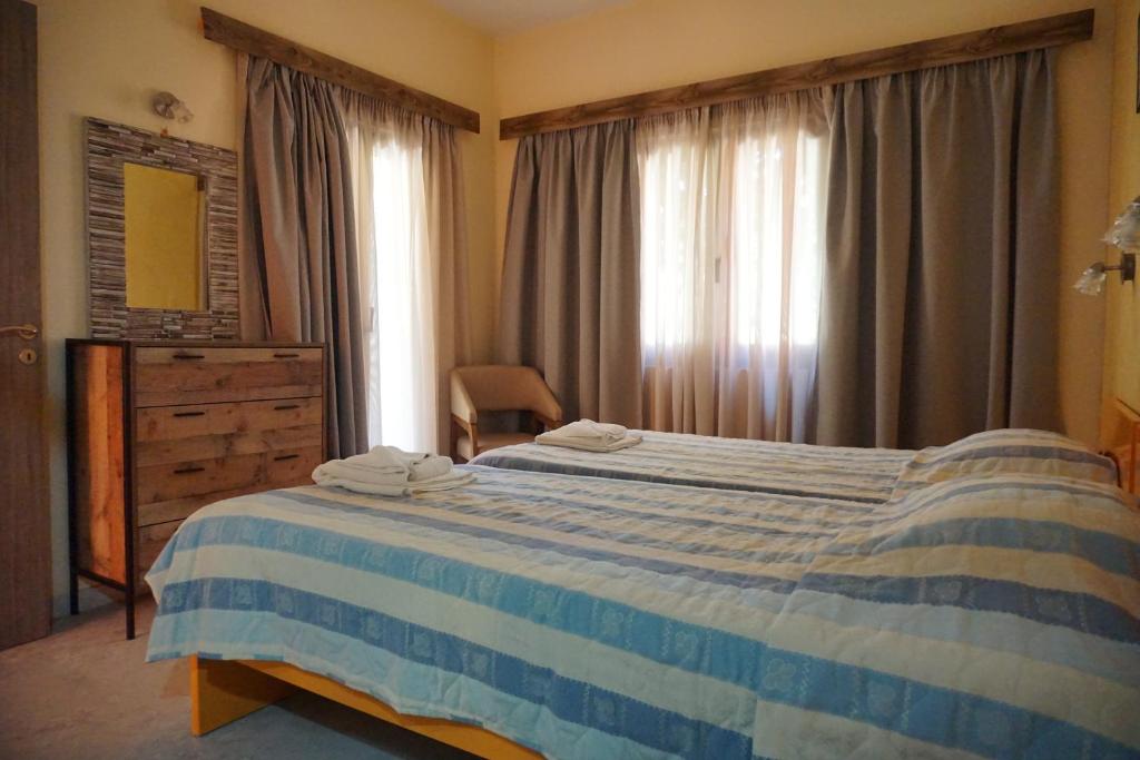 sypialnia z niebiesko-białym łóżkiem i oknem w obiekcie Katerini Apartments Hotel w mieście Platanes