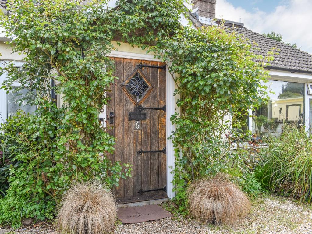 una puerta de madera en una casa con plantas en Kennelmans, en Sopley