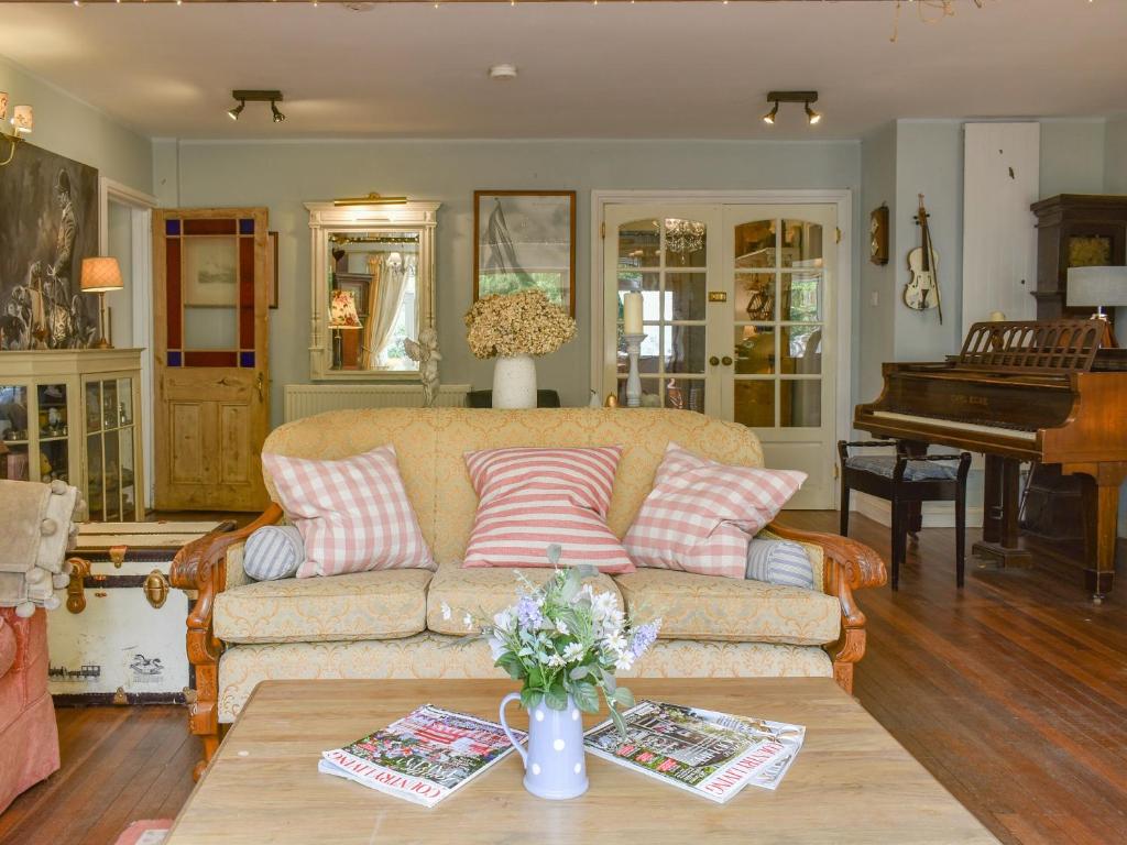 a living room with a couch and a piano at Kennelmans in Sopley