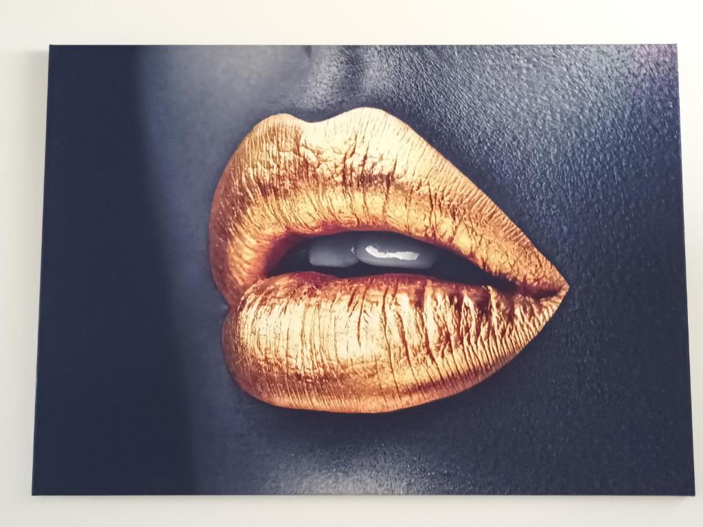 un gros plan de lèvres dorées sur un mur dans l'établissement Cap Agde Naturiste YETANATU, au Cap d'Agde