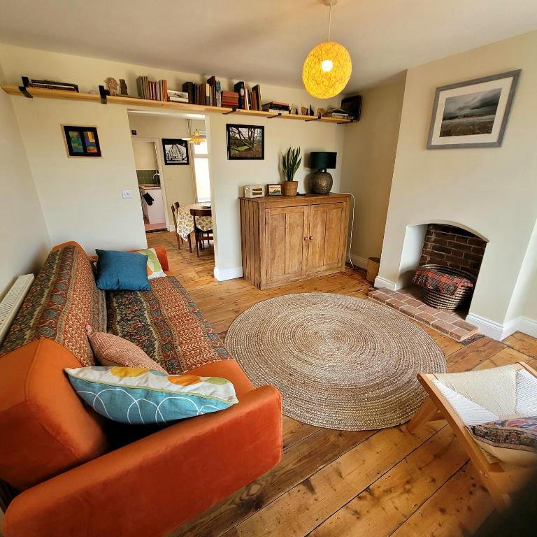 a living room with a couch and a fireplace at Pea Cottage Dog friendly and 5 mins to beach in Kessingland