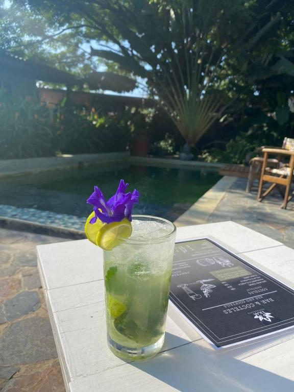 a drink on a table with a purple flower in it at Ekaa Hotel in Palomino