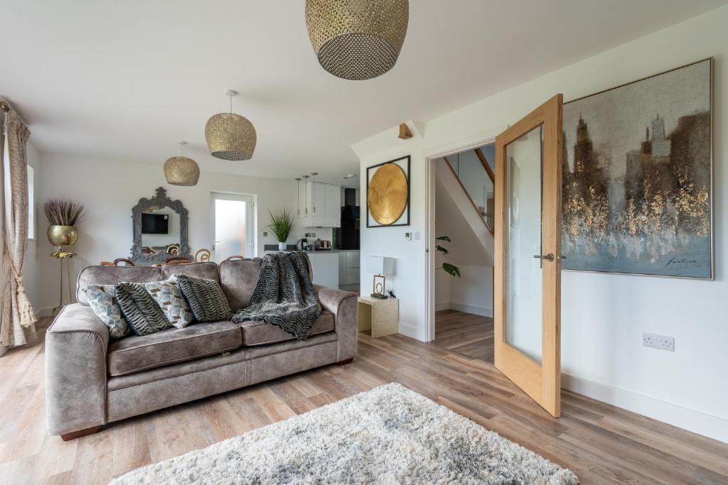 a living room with a couch and an open door at Luxurious 3 bedroom house Shangri la in village of Alfrick with free off road parking for 3 cars in an area of outstanding natural beauty, superb walking,close to Worcester, Malvern showground, theatre, Malvern hills, dogs welcome in Worcester