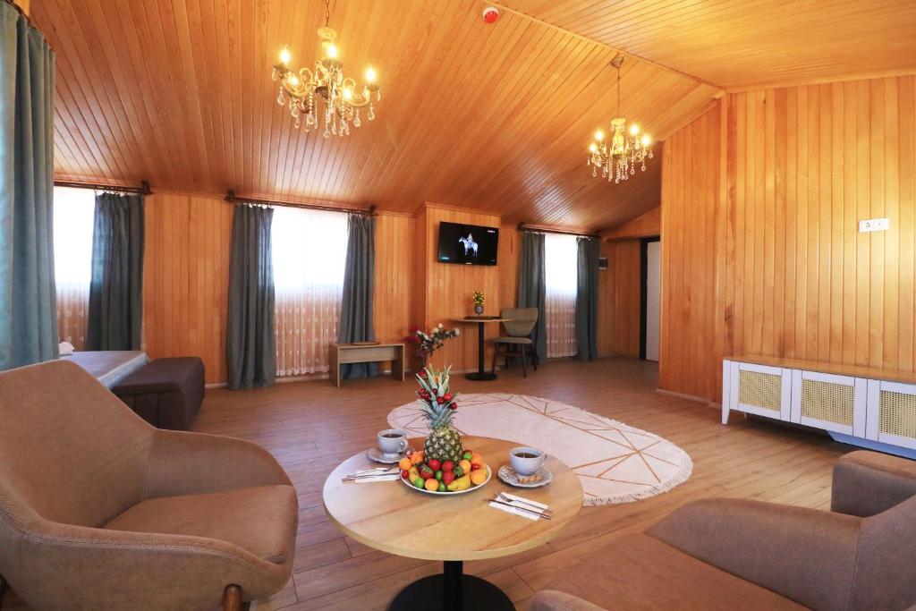 een woonkamer met een tafel en stoelen bij ALMIRCAN HOTEL in Trabzon