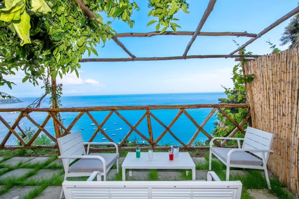 a table and chairs with a view of the ocean at Villa Briganti Seaview Terrace in Positano