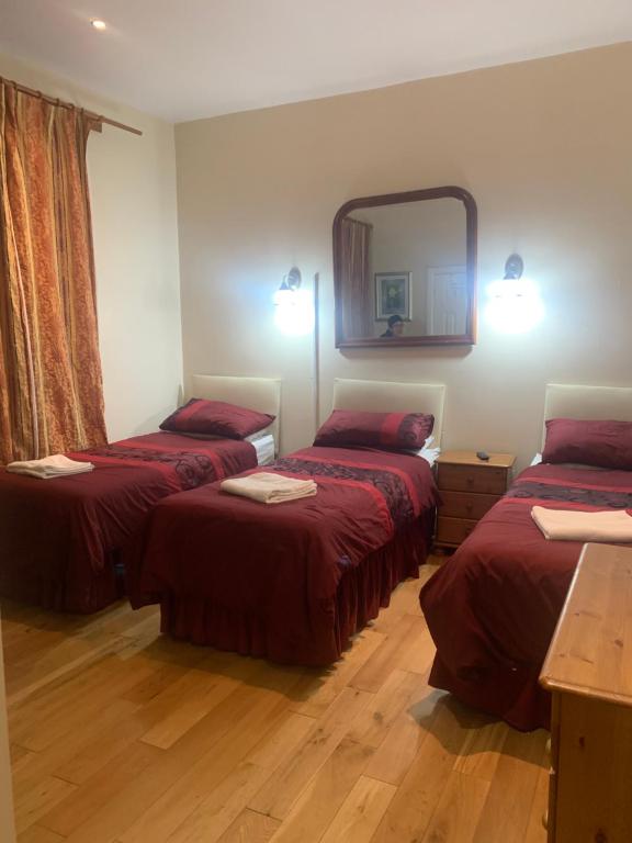 a hotel room with two beds and a mirror at The Dharma Lodge in Enfield