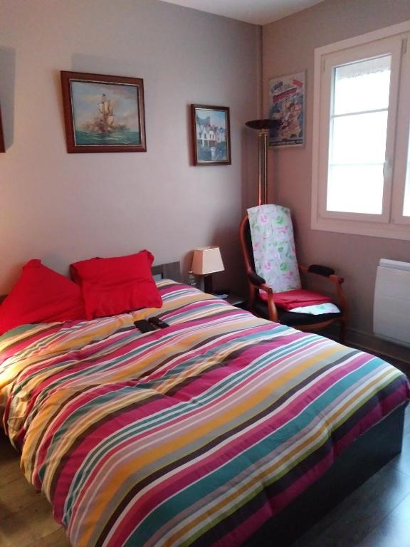 - une chambre avec un lit coloré et une chaise dans l'établissement LE TREPORT 2P 30M2 RDC tout à pied 2mn plage port funiculaire casino, au Tréport