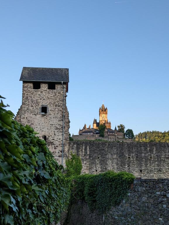 a tall stone wall with a castle in the background at Ferienwohnung an der historischen Stadtmauer in Cochem
