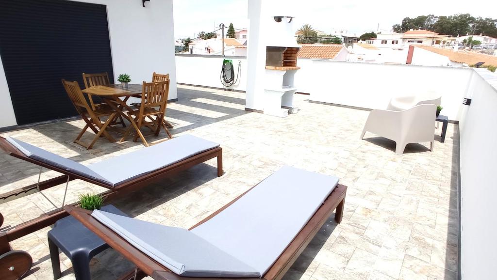 a patio with chairs and a table on a roof at MyHome Olhão in Olhão