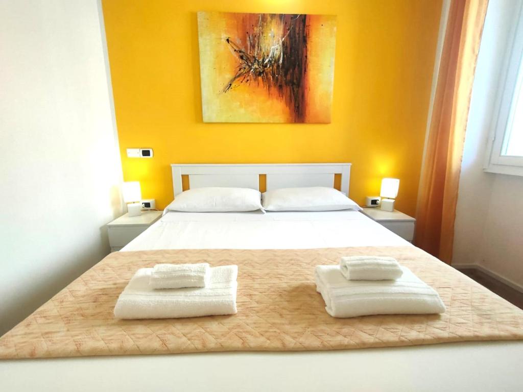 a bedroom with a bed with two towels on it at Iris Rooms in Cagliari