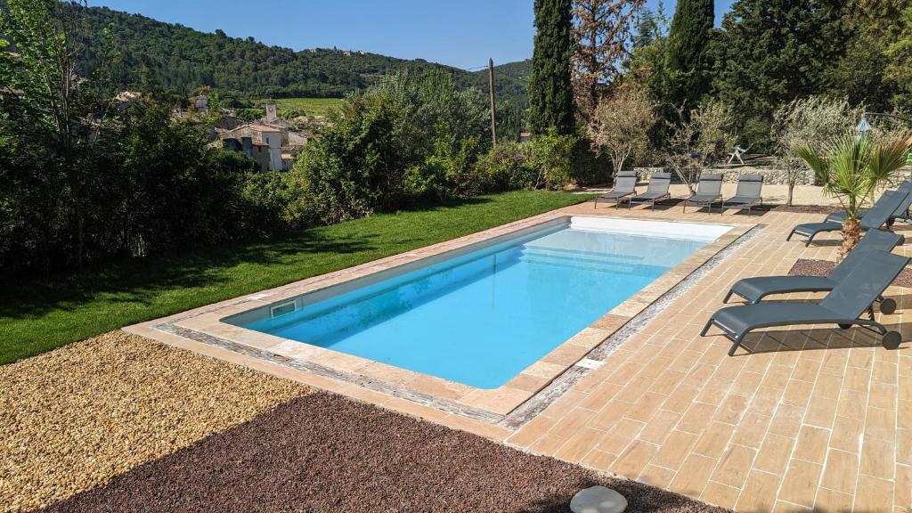 una piscina en un patio con 2 tumbonas en Mas des Coccinelles, en Mollans-sur-Ouvèze