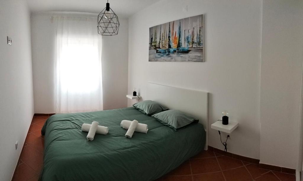 a bedroom with a bed with two crosses on it at Casas da Cacilda II in Nazaré