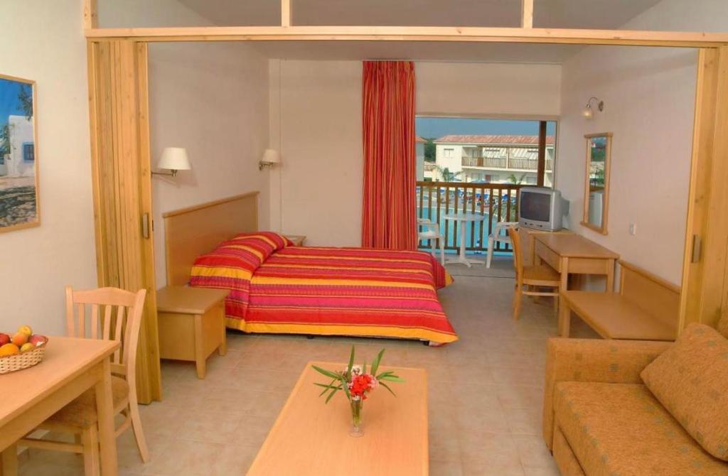 a hotel room with a bed and a living room at Tsokkos Paradise Holiday Village in Ayia Napa