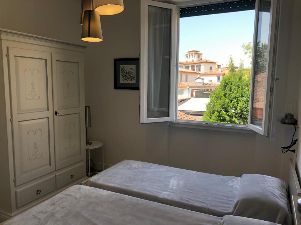 Leonardo luxury apartment في فلورنسا: غرفة نوم بسرير ونافذة كبيرة