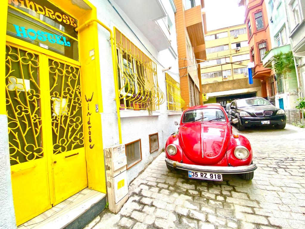 a small red car parked in front of a building at Windrose Hostel Istanbul in Istanbul