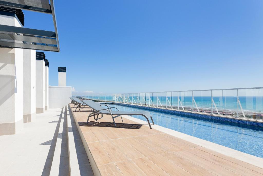 balcone di un edificio con piscina di Apartamentos con terraza frente al mar by Color Flats a Canet de Berenguer