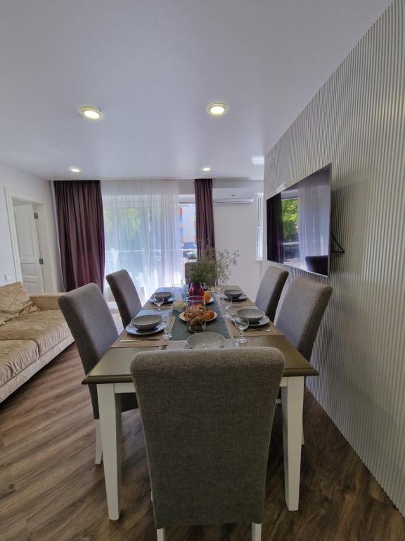 a dining table and chairs in a living room at Oškinio Apartamentai in Palanga