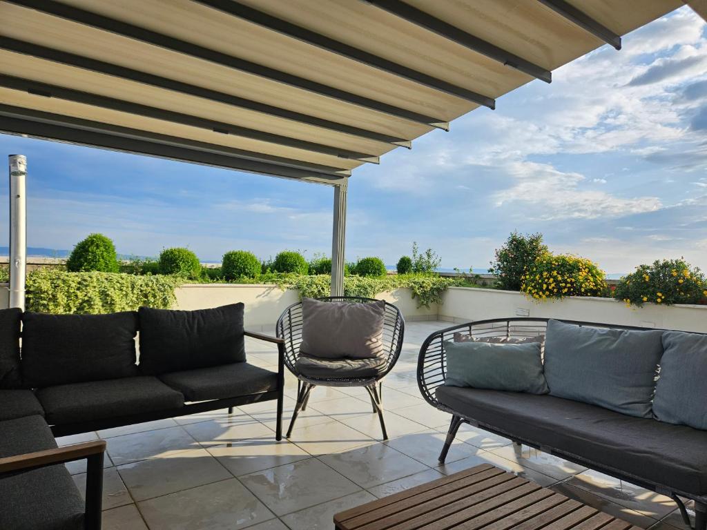 un patio con 2 sofás, una mesa y sillas en Tajla Rooms en Split