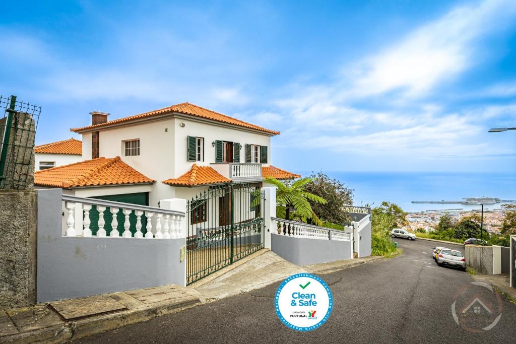 a white house with a fence and a street at Garden House in Funchal