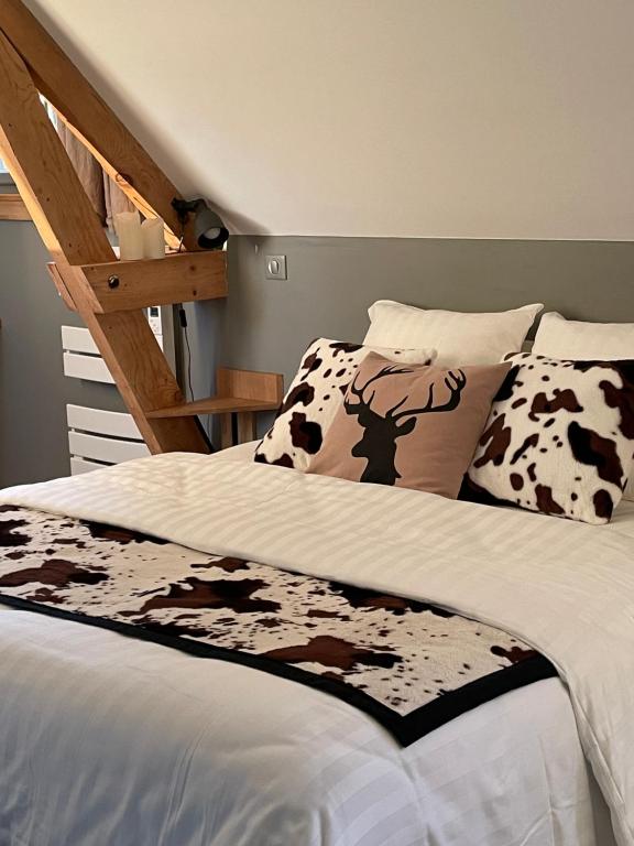 um quarto com uma cama com um cobertor de vaca e uma escada em La Bastide de Barbizon em Barbizon