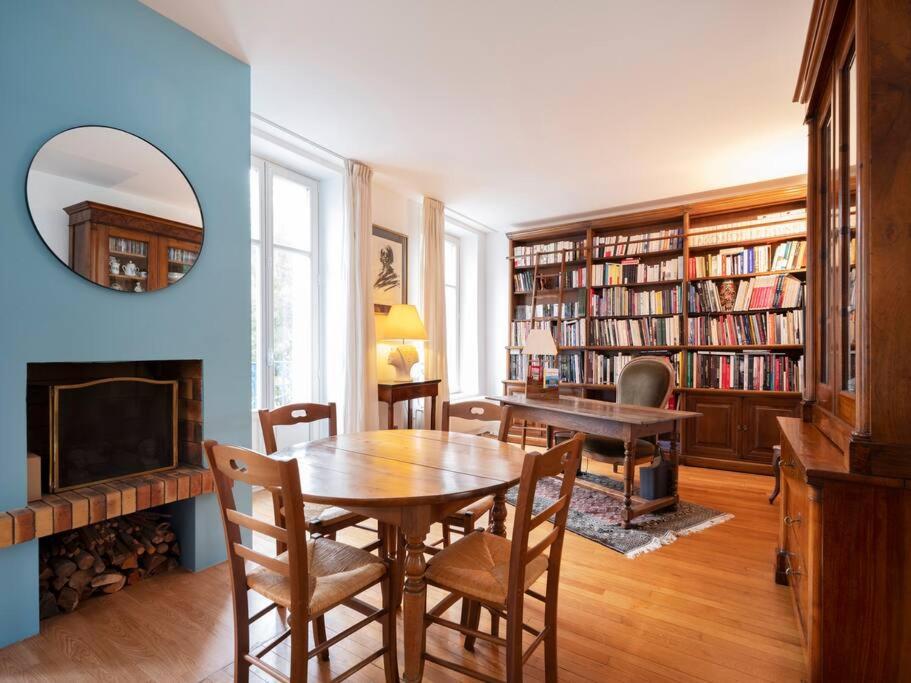 une salle à manger avec une table et une cheminée dans l'établissement Lumineux de Gallé, à Nancy