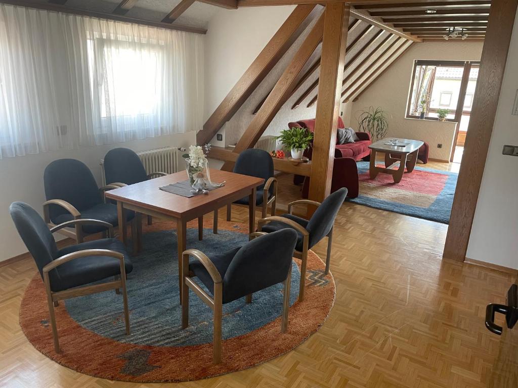 Habitación con mesa, sillas y sala de estar. en Naturpark Ferienwohnung mit Wintergarten en Spraitbach