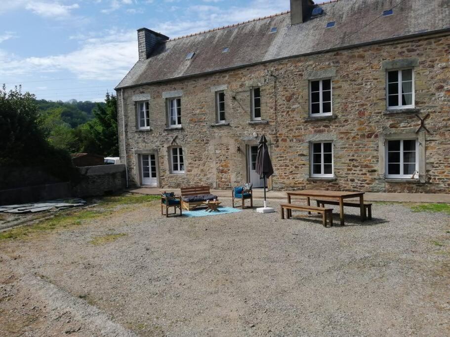 a stone building with picnic tables in front of it at Jolie maison en pierre proche centre-ville in Cherbourg en Cotentin
