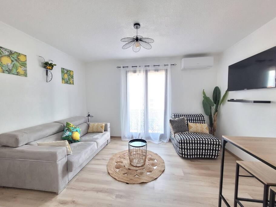 a living room with a couch and a table at Studio Limonista - cœur Saint Aygulf in Fréjus