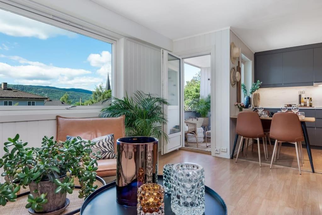 a living room with a table and a kitchen with a view at Beautiful apartment in the middle of Lillehammer. in Lillehammer