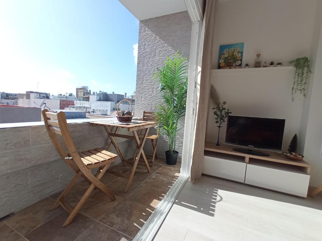 balcón con mesa y TV en el techo en Sunshine, What else?, en Las Palmas de Gran Canaria