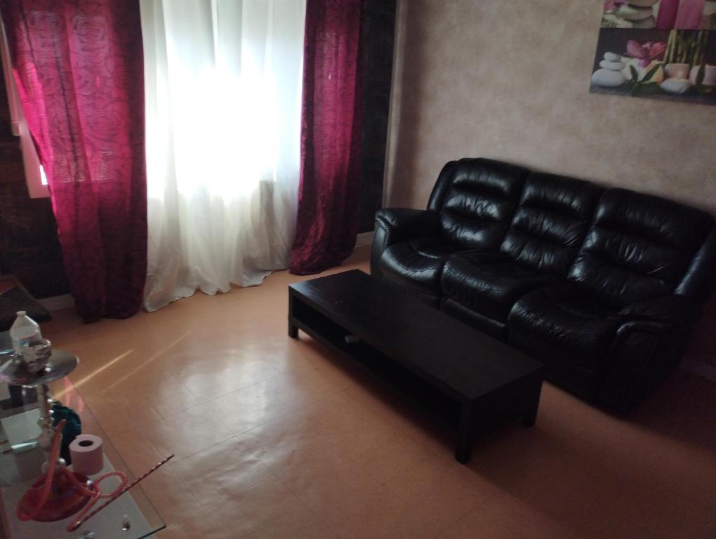- un salon avec un canapé en cuir noir et une table dans l'établissement Ben heber, à Sotteville-lès-Rouen