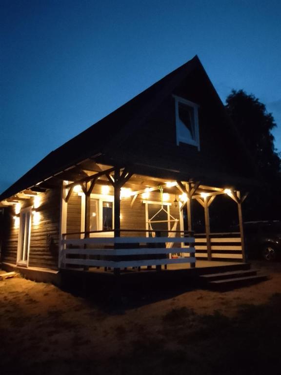 a house lit up at night with lights on it at Letniskowiec Kownatki in Siemienowo