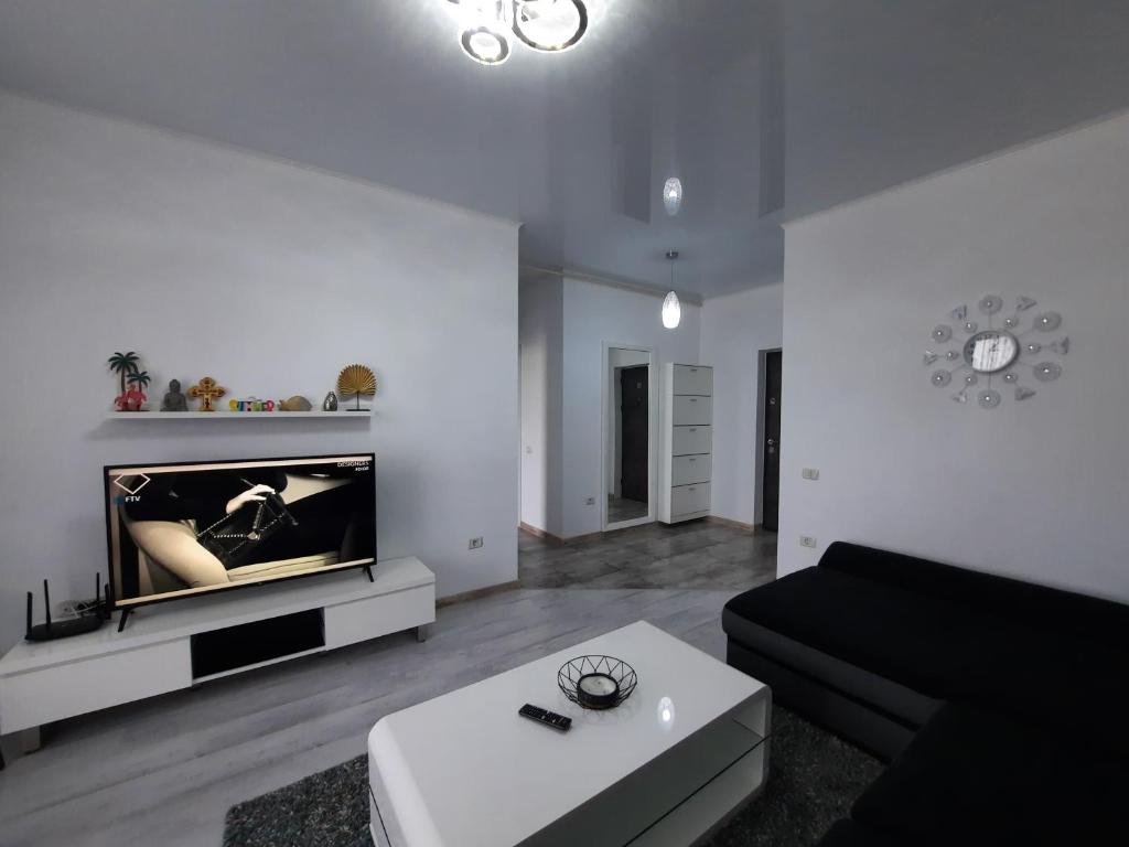 salon z kanapą i telewizorem w obiekcie Mamaia Apartament Bucurie & Liniste w mieście Năvodari