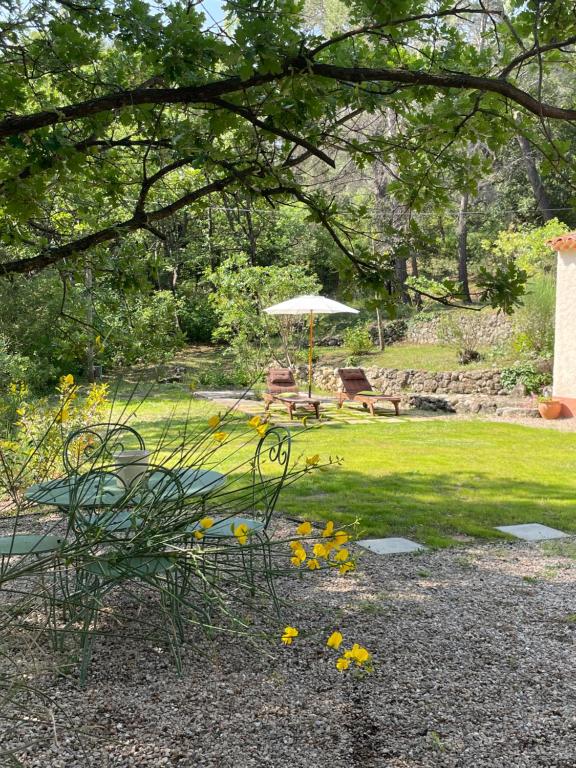 un jardín con mesa de picnic y sombrilla en hameau de prebarjaud, en Fayence