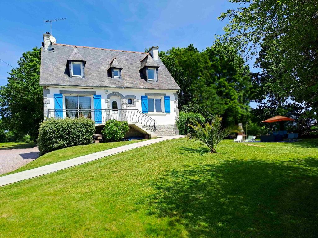 une maison blanche avec volets bleus sur une pelouse verte dans l'établissement Maison de 3 chambres avec jardin amenage et wifi a Saint Alban a 3 km de la plage, à Saint-Alban