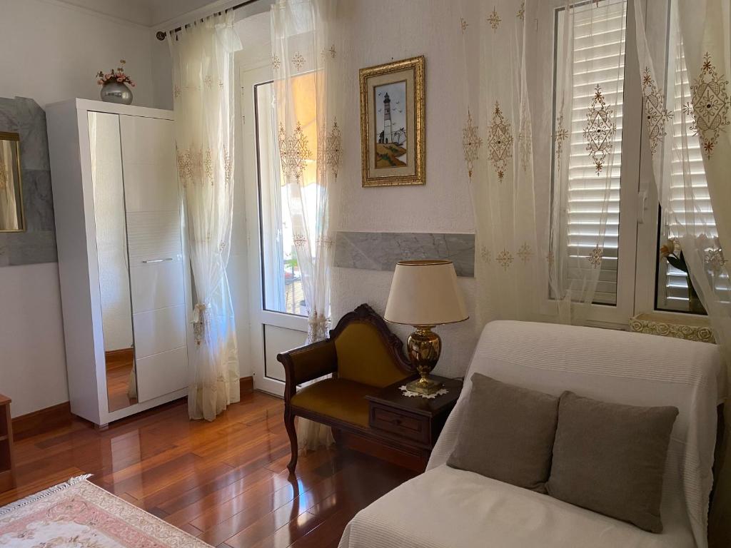a living room with a bed and a chair and windows at Studio Apartment Naya in Mali Lošinj