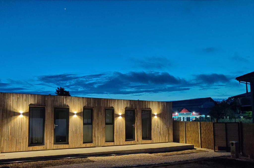 una recinzione di legno con luci accese di notte di Daro tiny house a Vama Veche